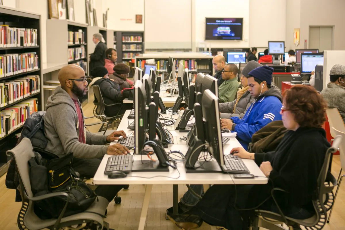 People work on computers at the recently renovated Washington Heights public library in Manhattan on Dec. 10, 2014. (Benjamin Chasteen/Epoch Times)