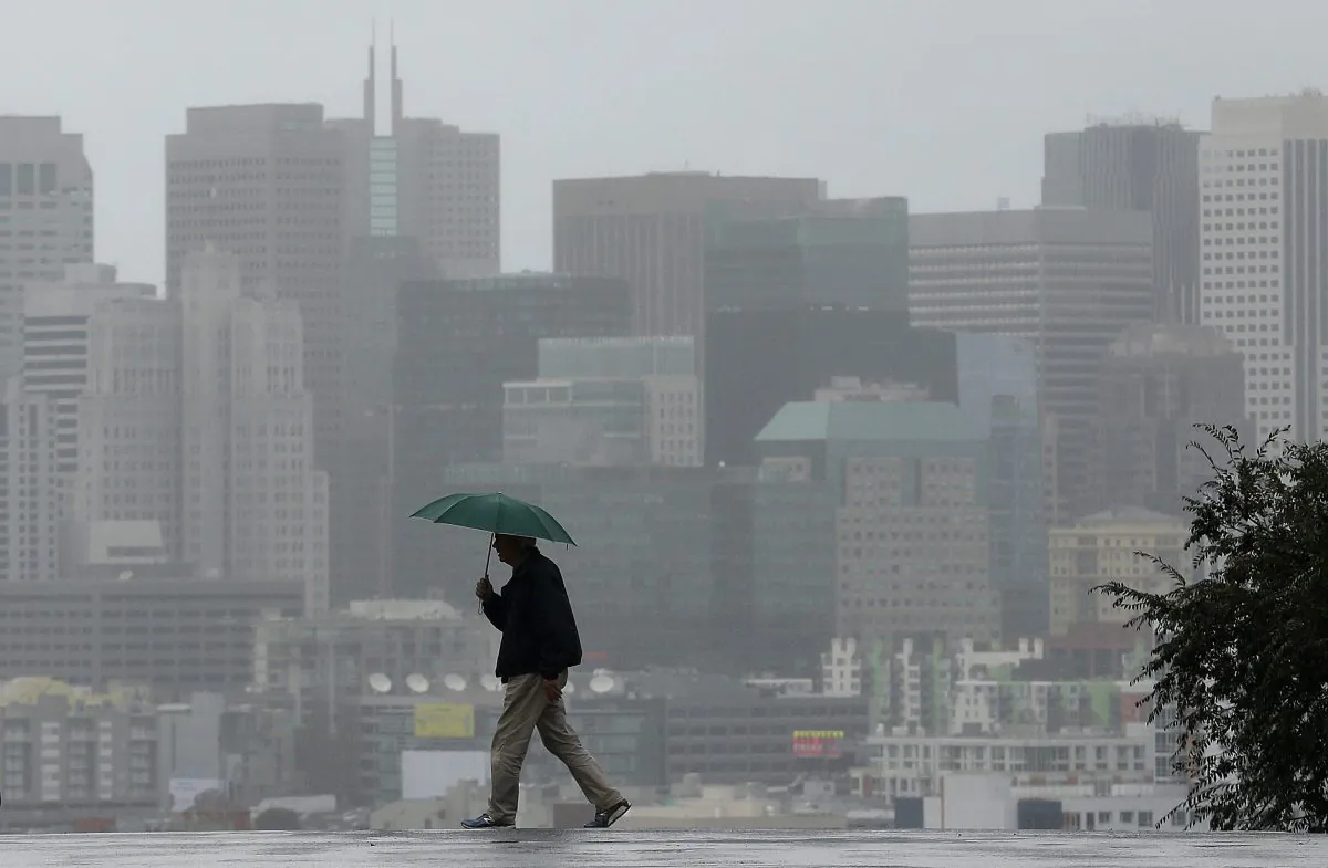 Richard Polich crosses a street in the rain on Tuesday, Jan. 5, 2016, in San Francisco. (AP Photo/Jeff Chiu)