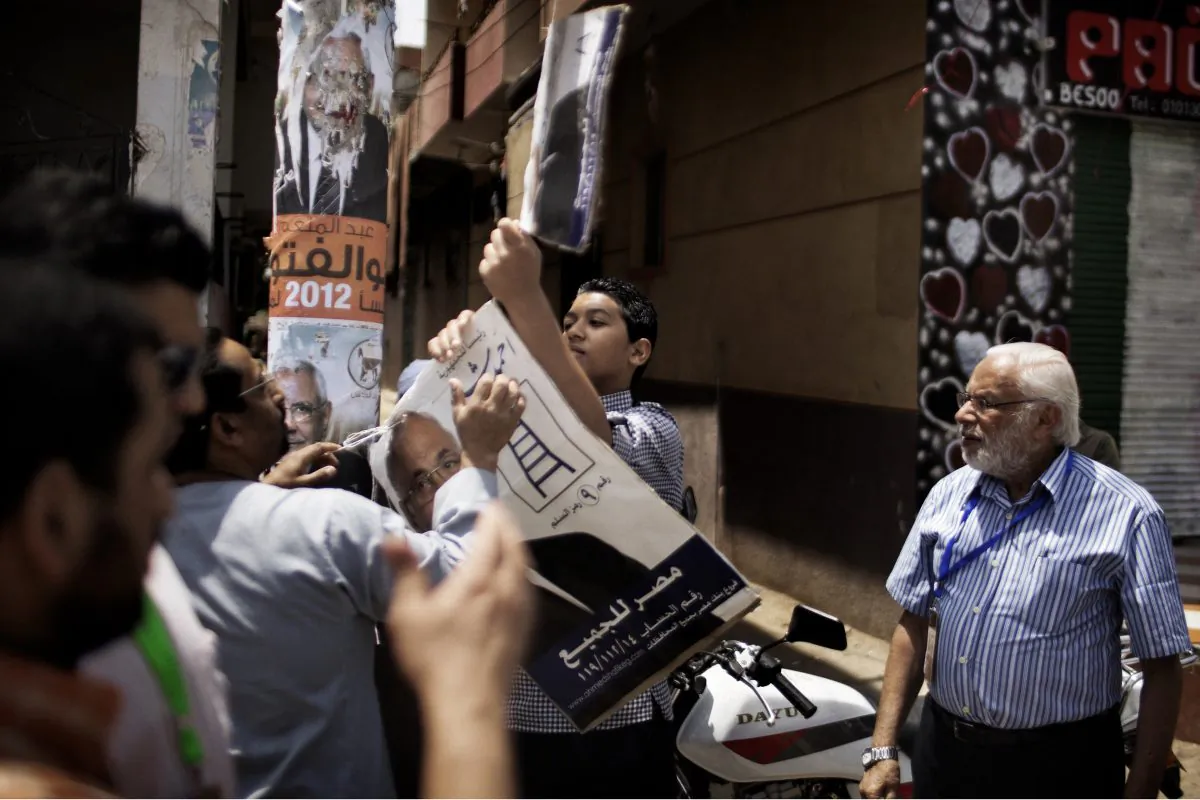 Egyptian political activist and electoral monitor, George Ishak (R), oversees the removal of campaign posters outside a polling station in the rural village of Namoul, in the village of Namul, north of Cairo, on the second day of the country's landmark presidential election on May 24, 2012. (Marco Longari/AFP/GettyImages)