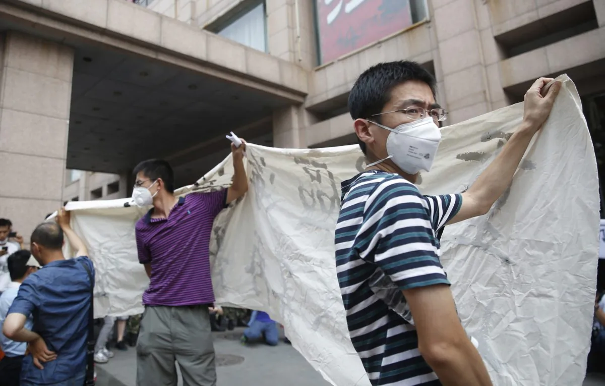 Residents, whose homes were destroyed in the explosion at a chemical warehouse last week, protest outside the hotel where authorities are holding a press conference in Tianjin on August 17, 2015.(STR/AFP/Getty Images)