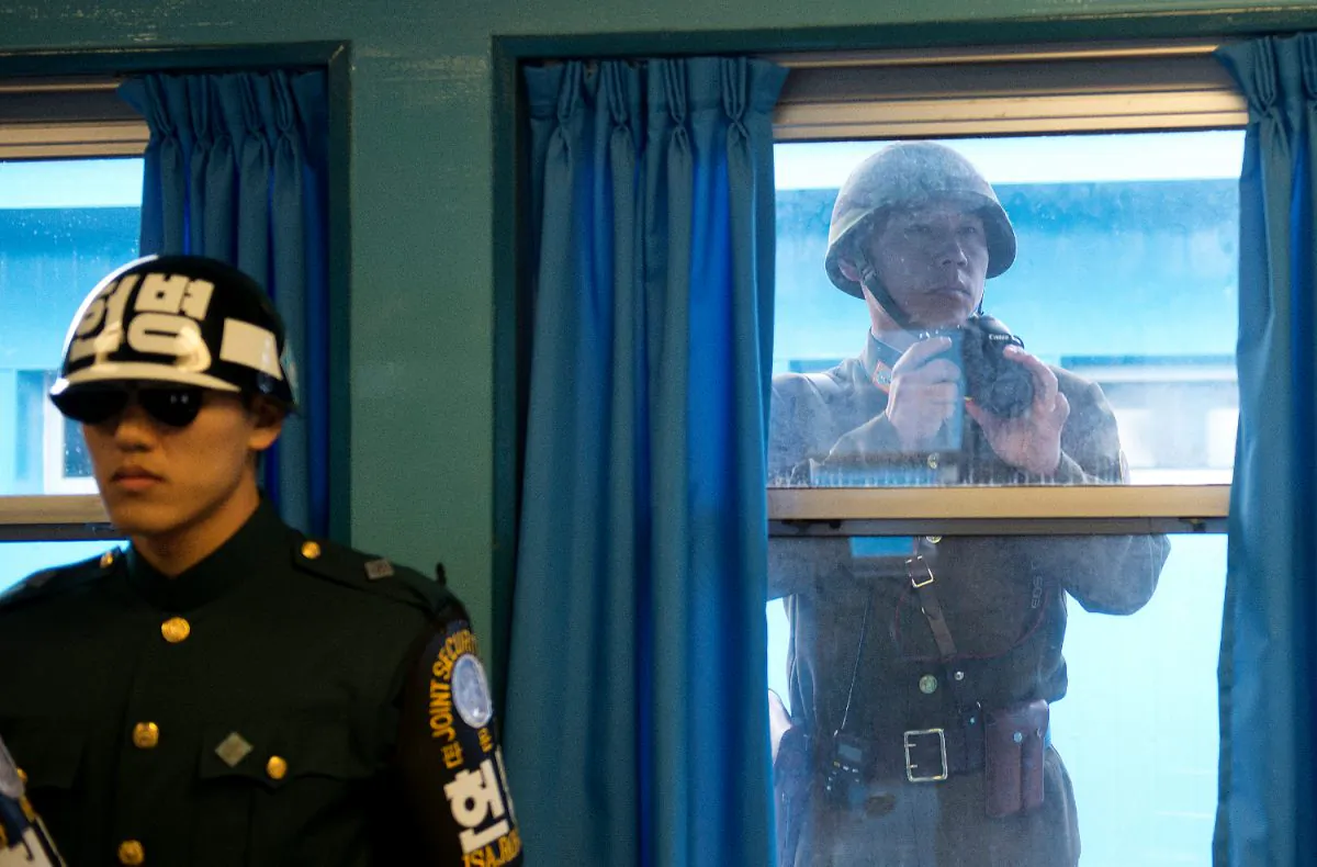 A North Korean Soldier takes photos through the window while U.S. Army Gen Martin E. Dempsey, chairman of the Joint Chiefs of Staff, is briefed at the demilitarized zone in South Korea on Nov. 11, 2012. (D. Myles Cullen/Department of Defense)