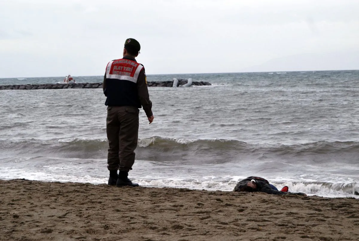 A Turkish paramilitary police officer stands next to the body of a migrant lying on the beach in Ayvalik, Turkey, Tuesday, Jan. 5, 2016. (AP Photo)
