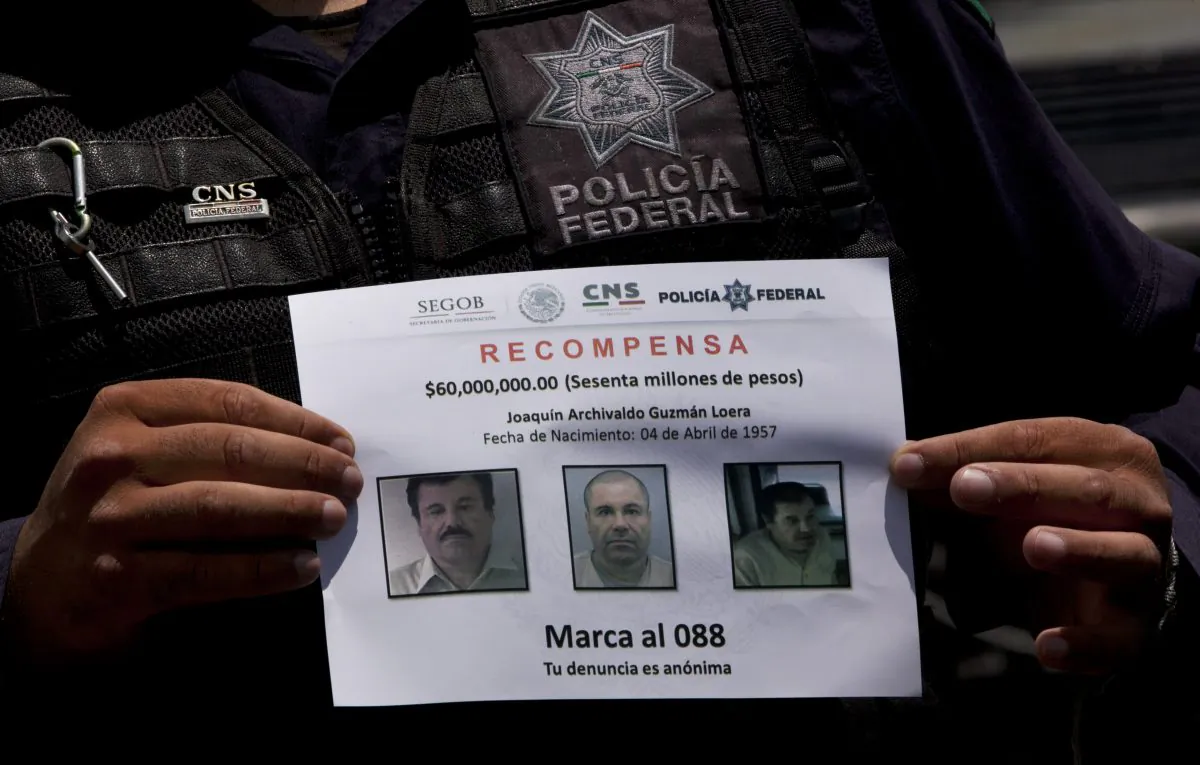 In this July 16, 2015 file photo, a Federal Police shows a reward notice for information leading to the capture of drug lord Joaquin "El Chapo" Guzman, who made his escape from the Altiplano maximum security prison via an underground tunnel, in Almoloya, west of Mexico City. (AP Photo/Marco Ugarte)