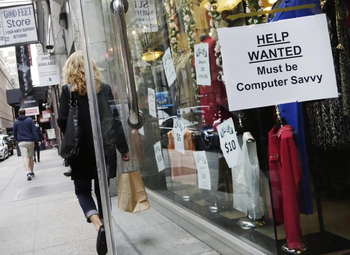 A shopper walks past a store with a "Help Wanted" sign in the window in New York on Oct. 1, 2015. (AP Photo/Mark Lennihan)