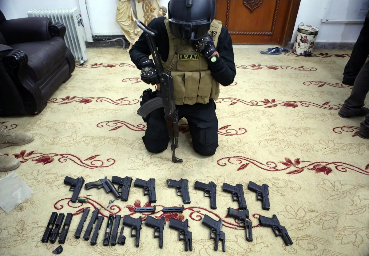 A policeman displayed weapons used by murderers and thieves, at police headquarters in Basra, 340 miles (550 kilometers) southeast of Baghdad, Iraq, on Dec. 19, 2015. Local officials blame the lack of security forces, many of them have been dispatched to front lines, for the soaring thefts, armed robberies, kidnapping for ransom, bloody tribal disputes and drug trafficking. Residents complain that political infighting over government posts and growing influence of Shiite militias have exacerbated the situation and weakened the role of the remaining security forces in the province. (AP Photo/Nabil al-Jurani)