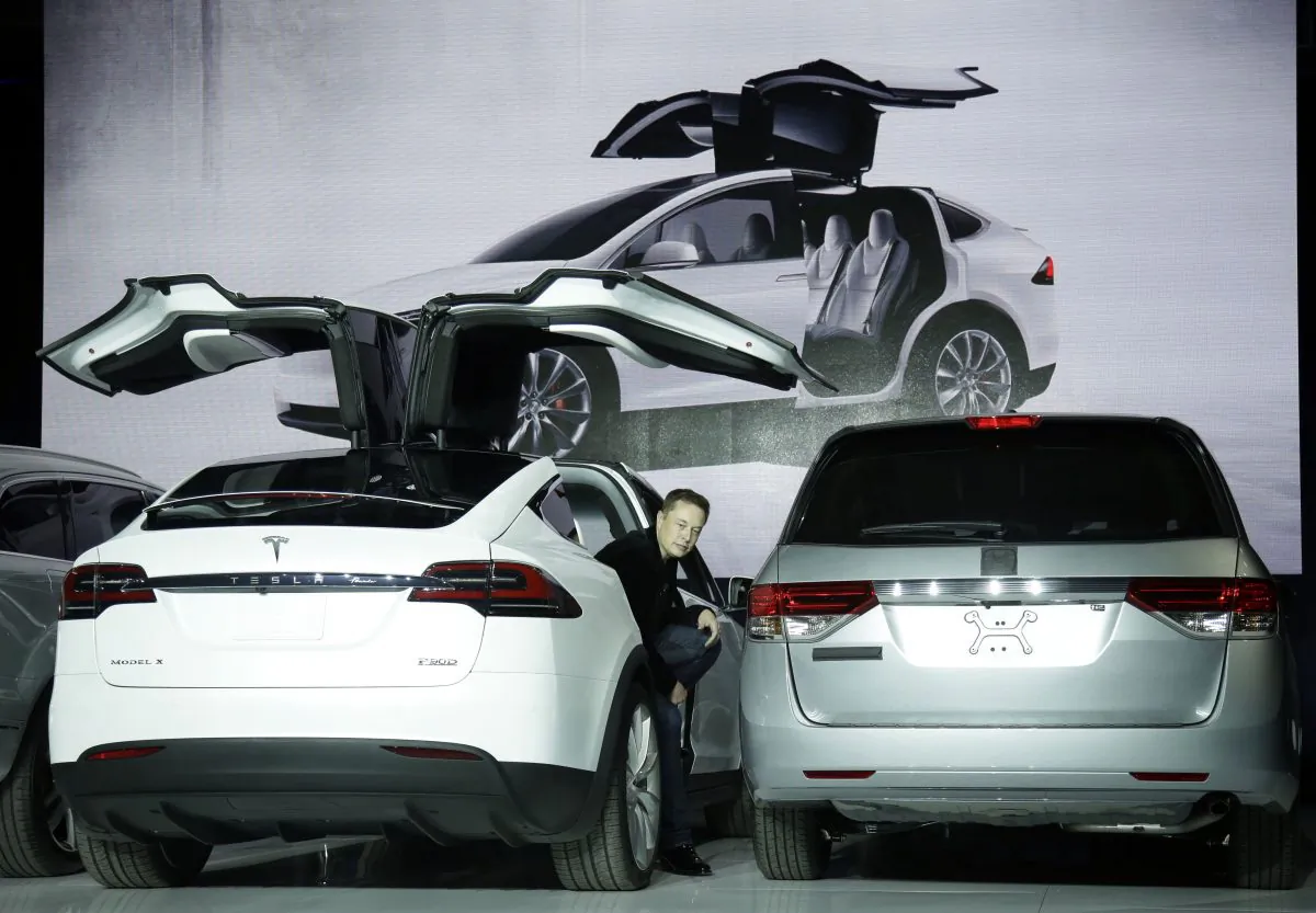 Elon Musk, CEO of Tesla Motors Inc., introduces the Model X car at the company's headquarters  in Fremont, Calif., Sept. 29, 2015. Tesla faces shareholder lawsuits that may delay its proposed merger with SolarCity. (AP Photo/Marcio Jose Sanchez)