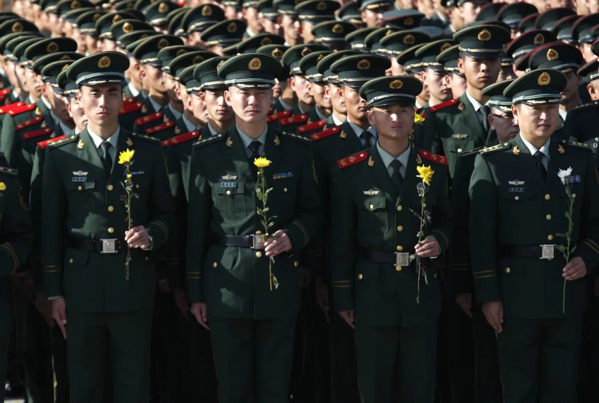 Chinese paramilitary soldiers hold flowers as they commemorate Martyrs' day in Heihe, northeast China's Heilongjiang province on September 30, 2015. CHINA OUT AFP PHOTO (Photo credit should read STR/AFP/Getty Images)