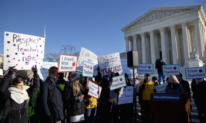 People participate in a rally at the Supreme Court in Washington, D.C., on Jan. 11, 2016, as the court heard arguments in the 'Friedrichs v. California Teachers Association' case. The justices were to hear arguments in a case that challenges the right of public-employee unions to collect fees from teachers, firefighters and other state and local government workers who choose not to become members. (AP Photo/Jacquelyn Martin)