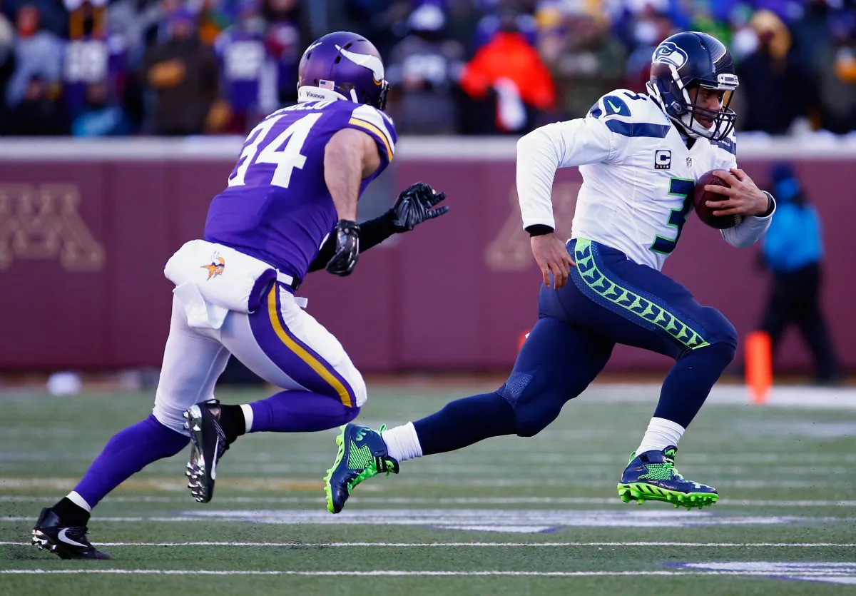 Russell Wilson runs with the ball with Andrew Sendejo in pursuit during the NFC Wild Card Playoff game at TCF Bank Stadium on Jan. 10, 2016 in Minneapolis, Minnesota. (Jamie Squire/Getty Images)
