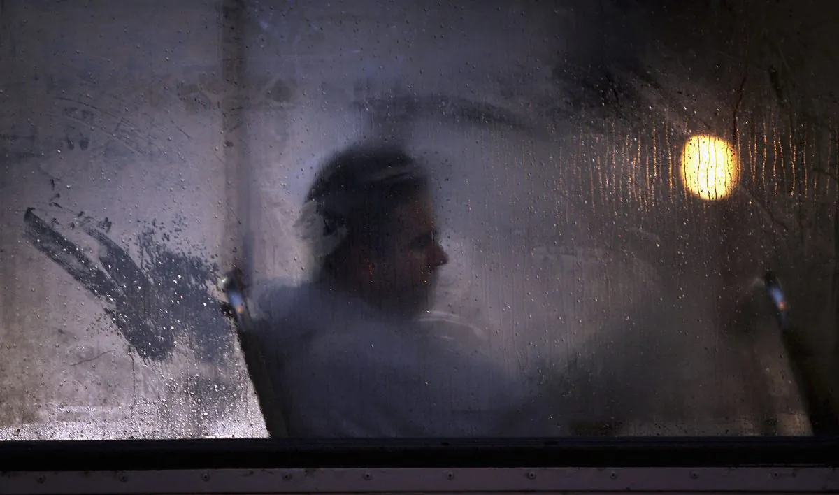 A man makes his way home from work on a bus as darkness falls in Glasgow, Scotland, on Oct. 10, 2005. (Christopher Furlong/Getty Images)