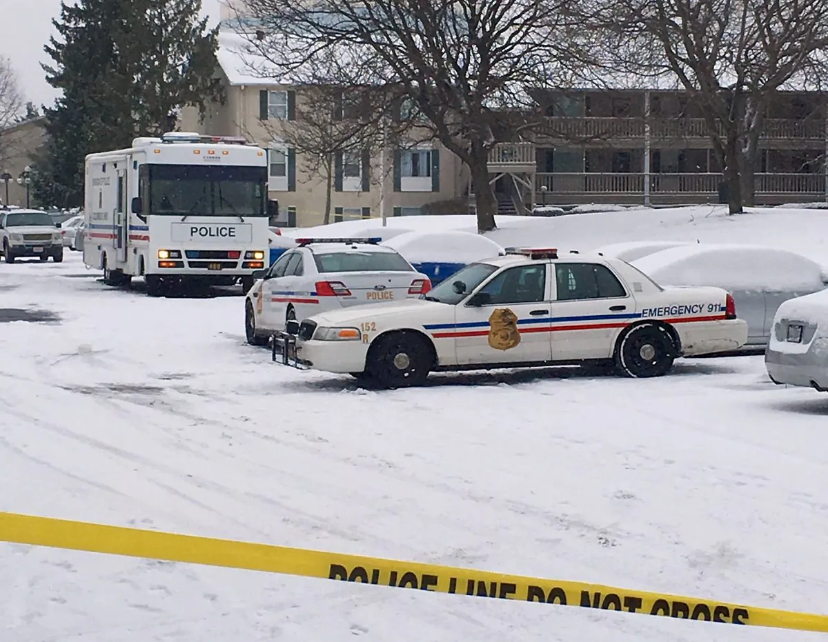 Police vehicles and crime scene tape surround an apartment complex, Tuesday, Jan. 12, 2016, on the north side of Columbus, Ohio, where police say a woman's ex-boyfriend forced his way into her apartment early Tuesday and fatally stabbed her and her two children before being critically injured in a knife fight with her current boyfriend.  (AP Photo/Mitch Stacy)