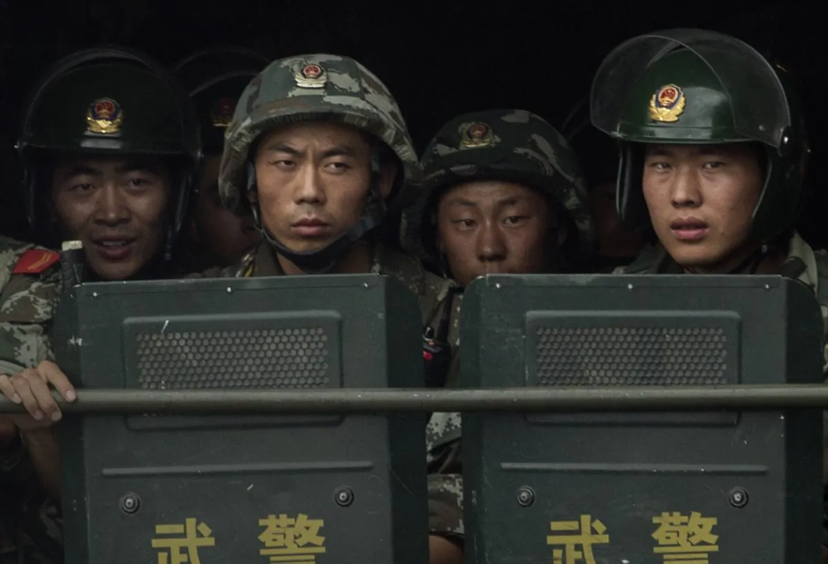 Chinese soldiers ride on the back of a truck as they patrol outside the Id Kah Mosque in Kashgar, China's Xinjiang region, on July 31, 2014. (Getty Images)