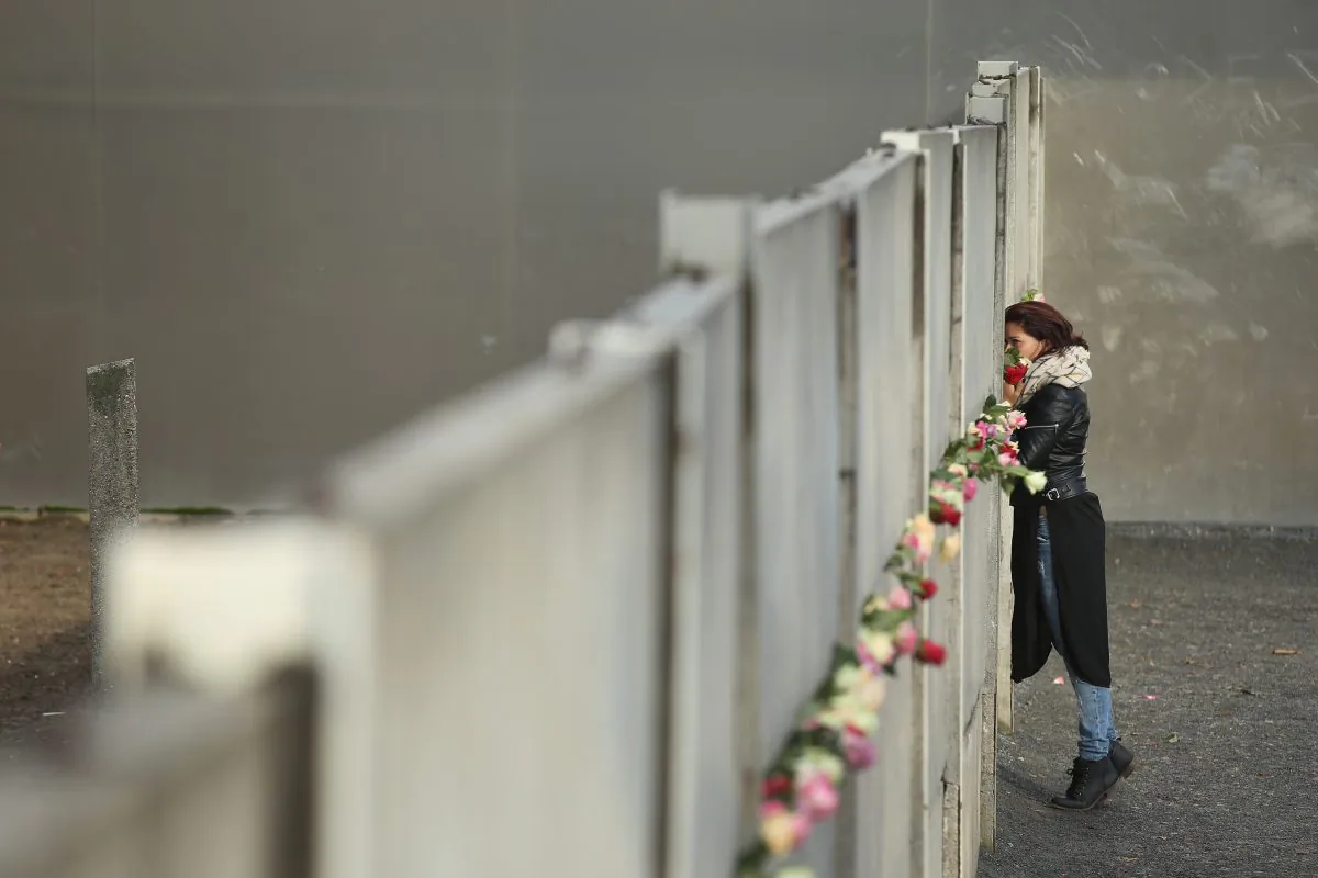A woman places flowers at the remains of the Berlin Wall on Nov. 9, 2015, the 26th anniversary of its demolition. From 1961 to 1989, the Wall, built to keep East Germans from emigrating to the democratic west, was a symbol of the Cold War and Soviet communism. (Sean Gallup/Getty Images)
