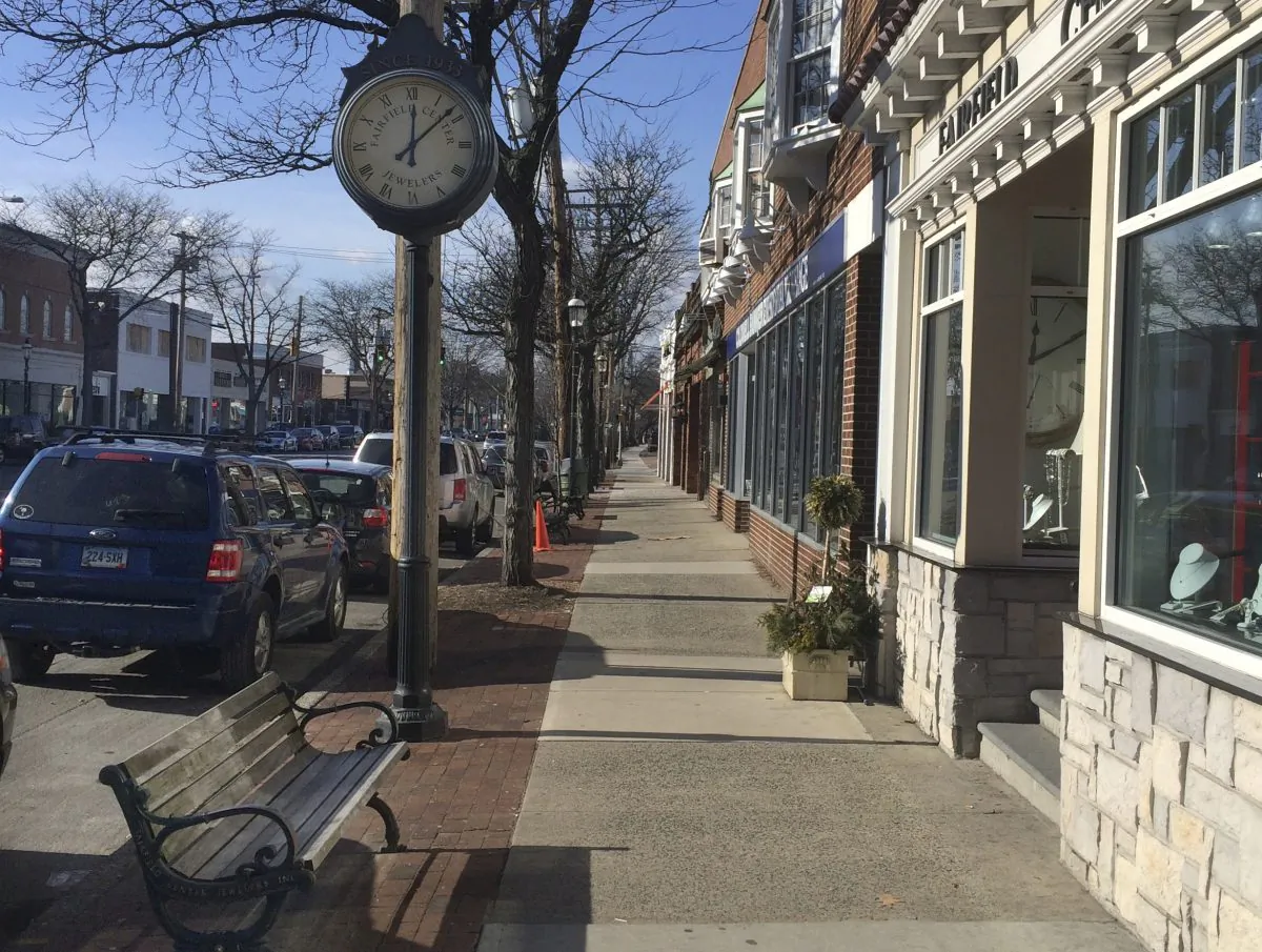 In this Thursday, Jan. 14, 2016 photo, the sun shines on shops along Post Road in Fairfield, Conn. General Electric said Wednesday it will begin relocating its global headquarters from its suburban campus in Fairfield to Boston in the summer, and complete the move by 2018. General Electrics relocation has many in Fairfield fretting over the loss of tax revenue, charitable spending, and the prestige that comes with being home to a $130 billion company.   (AP Photo/Michael Melia)