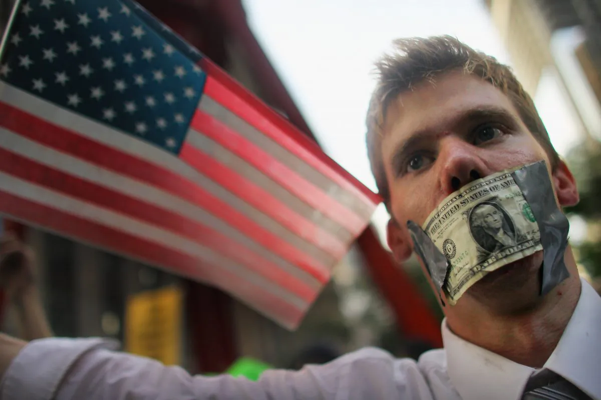 Americans aged 18 to 29 face an unemployment rate of 8 percent compared to 3.7 percent for those over 29, a study says. A protester wears a dollar bill over his mouth at the start of a march by demonstrators opposed to corporate profits on Wall Street in New York City on Sept. 30, 2011. (Mario Tama/Getty Images)