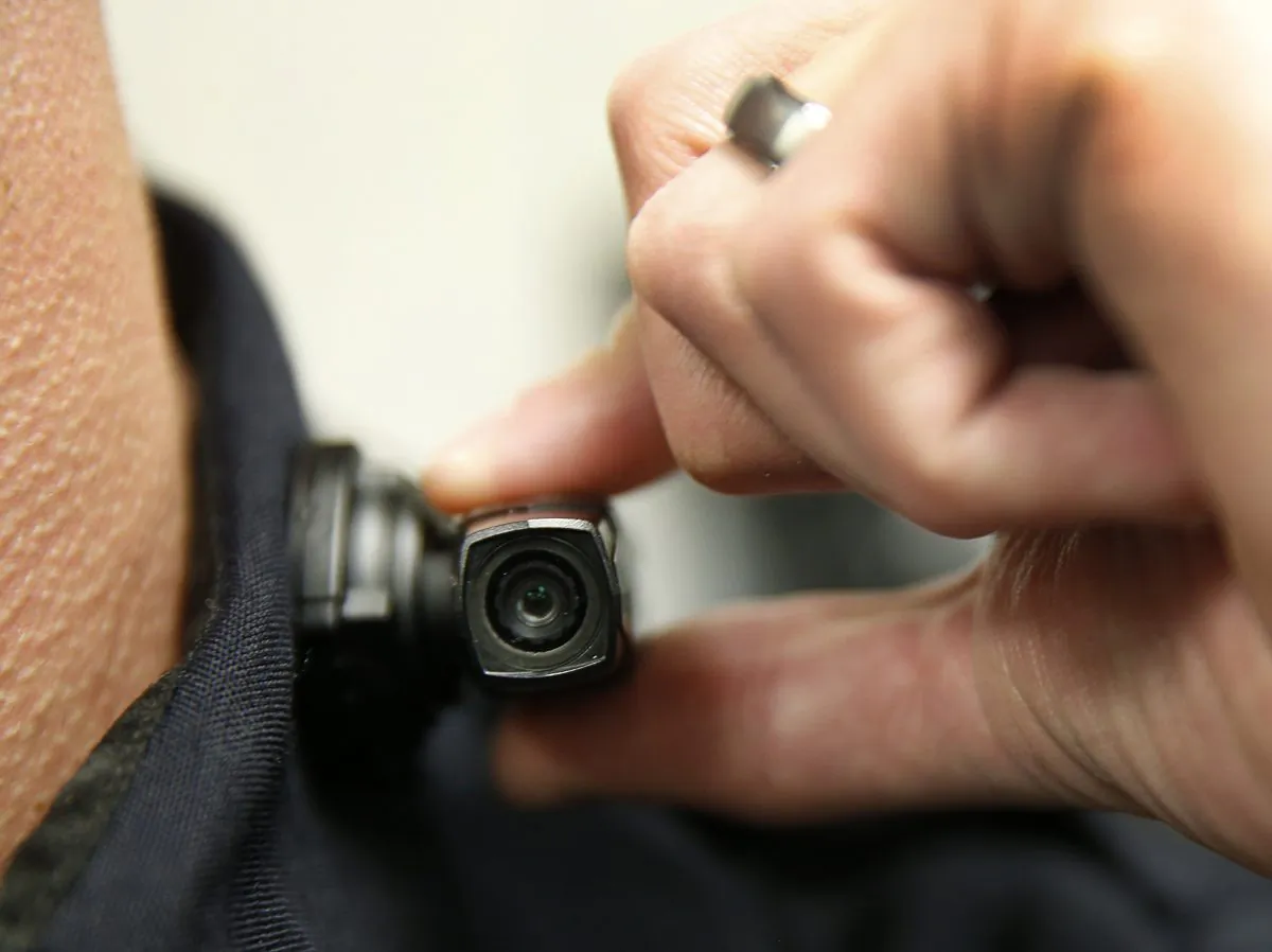 A West Valley City police officer shows off a newly-deployed body camera attached to his shirt collar in West Valley City, Utah, on March 2, 2015. West Valley City Police Department has issued 190 Taser Axon Flex body cameras for all it's sworn officers to wear. (George Frey/Getty Images)