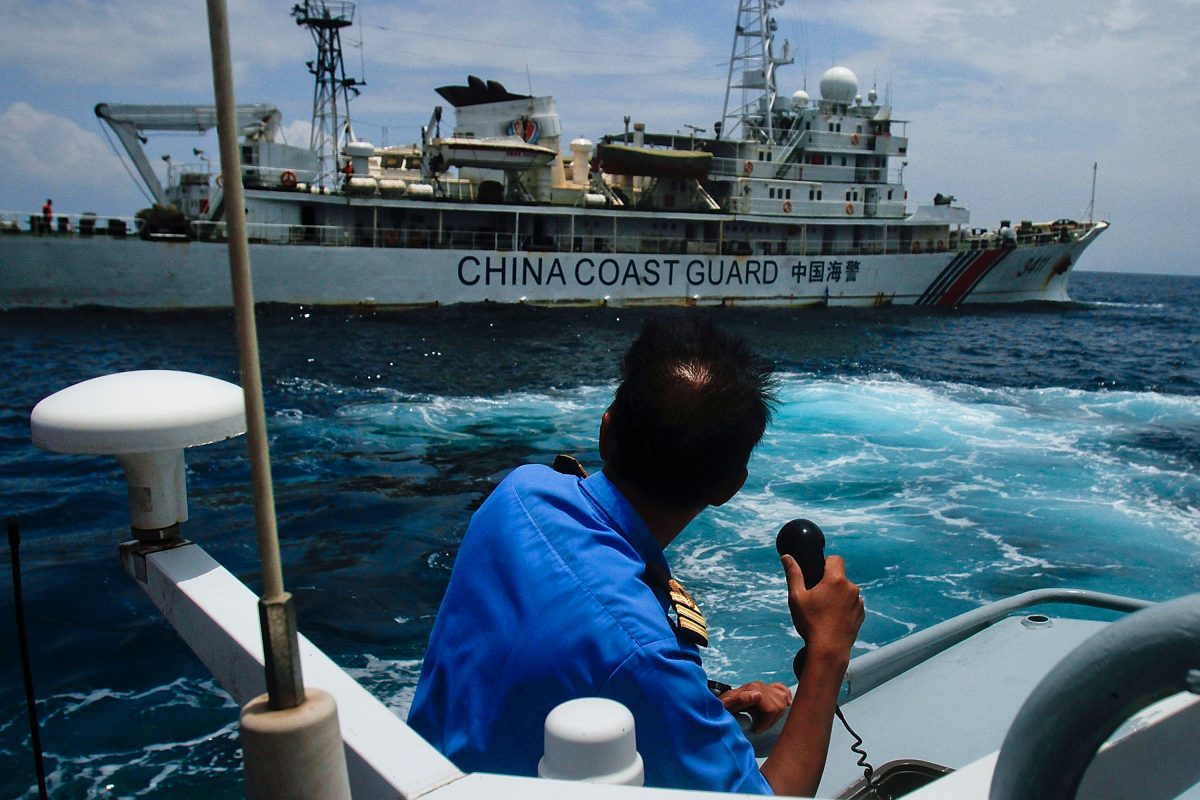 Chinese "little blue men" maritime militia in South China Sea. A member of the Malaysian Navy at a communication exchange with a Chinese Coast Guard ship in the South China Sea, near Kuantan, Malaysia, on March 15, 2014. (Rahman Roslan/Getty Images)