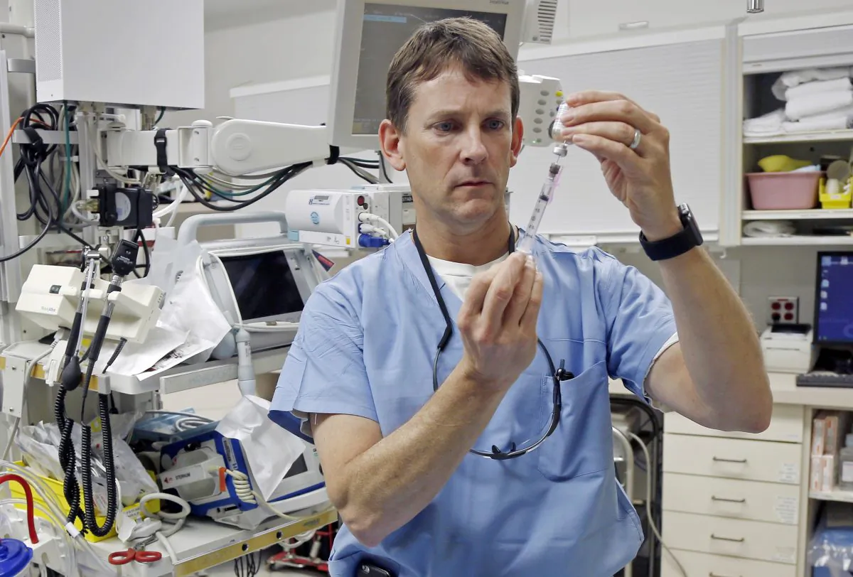 Dr. John Hick, a Hennepin County Medical Center emergency physician and a national expert in disaster planning, demonstrates preparation of an injection at the Hennepin County Medical Center in Minneapolis on Jan. 14, 2016. At the prodding of the federal government, state health departments nationwide are hurrying to complete "Crisis Standards of Care" plans to guide medical professionals in such catastrophes and determine what should trigger them. (AP Photo/Jim Mone)