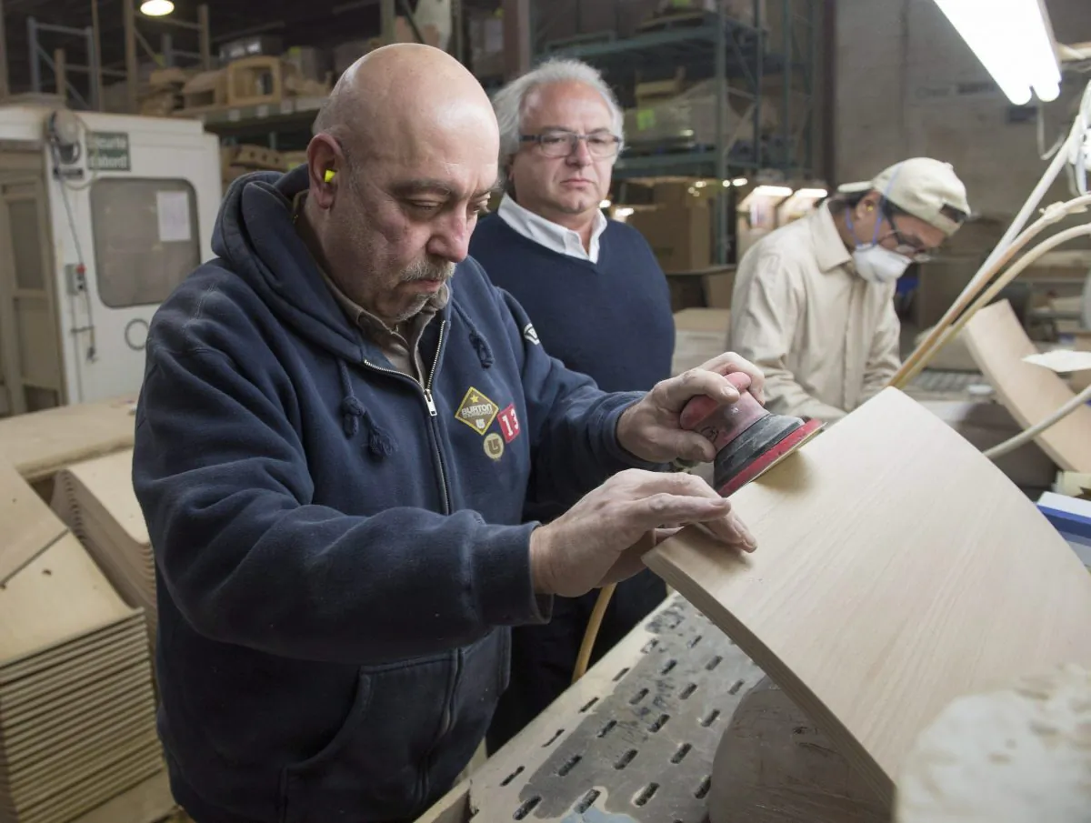 Syrian refugee Garouj Nazarian (L) works at the Seatply Products factory as owner Levon Aseyan looks on, Jan. 18, 2016, in Montreal. The plywood company employs and helps integrate refugees from around the world. (The Canadian Press/Ryan Remiorz)