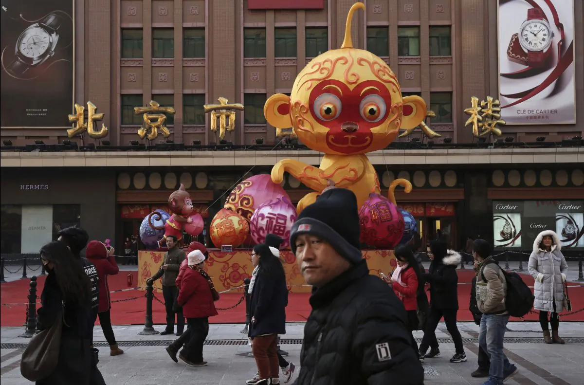 Chinese pedestrians walk passed a display for the upcoming Year of the Monkey for the Chinese New Year at a market on Jan. 19, 2016 in Beijing. (Kevin Frayer/Getty Images)