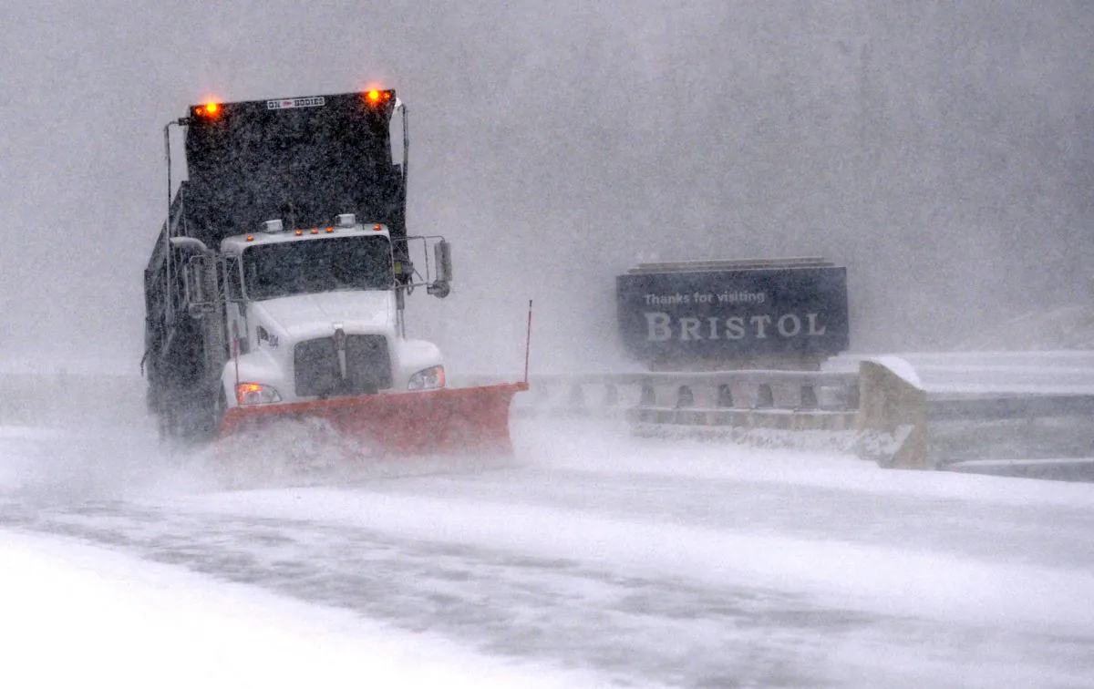 A snow plow works on clearing the Volunteer Parkway as snow falls, Wednesday, Jan. 20, 2016, in Bristol, Tenn. (Earl Neikirk/The Bristol Herald-Courier via AP)