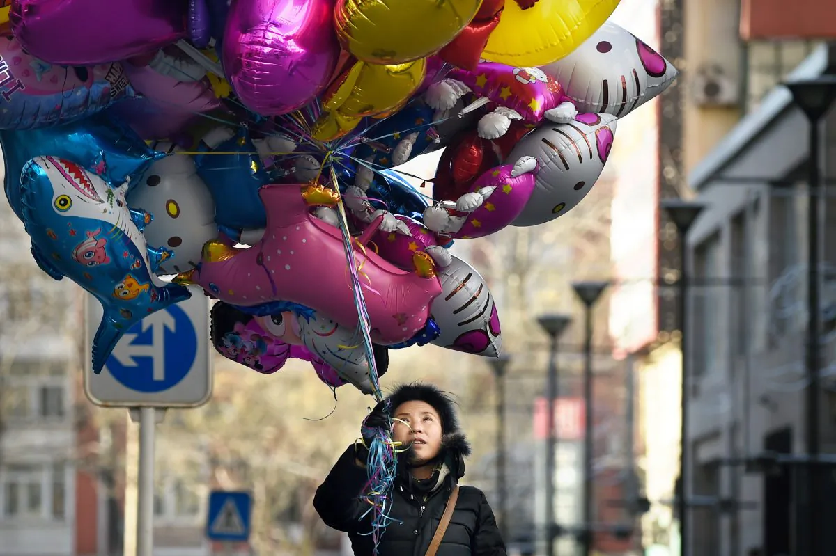 A balloon vendor waits for customers outside a shop in Beijing on Dec. 24, 2014. (Wang Zhao/AFP/Getty Images)