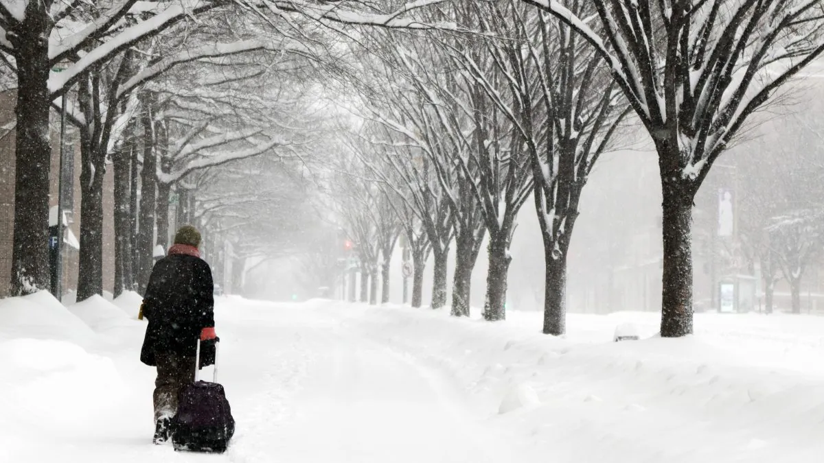 Michelle Navarre Cleary pulls a bag as she walks on K Street in Washington, D.C., on Jan. 23, 2016, as snow continues to fall. With long lead time from forecasters and stern warnings from authorities, tens of millions of residents from northern Georgia to New Jersey shuttered themselves inside to wait out a mammoth storm that made travel treacherous and could dump 2 feet or more of snow in some areas. (AP Photo/Jon Elswick)
