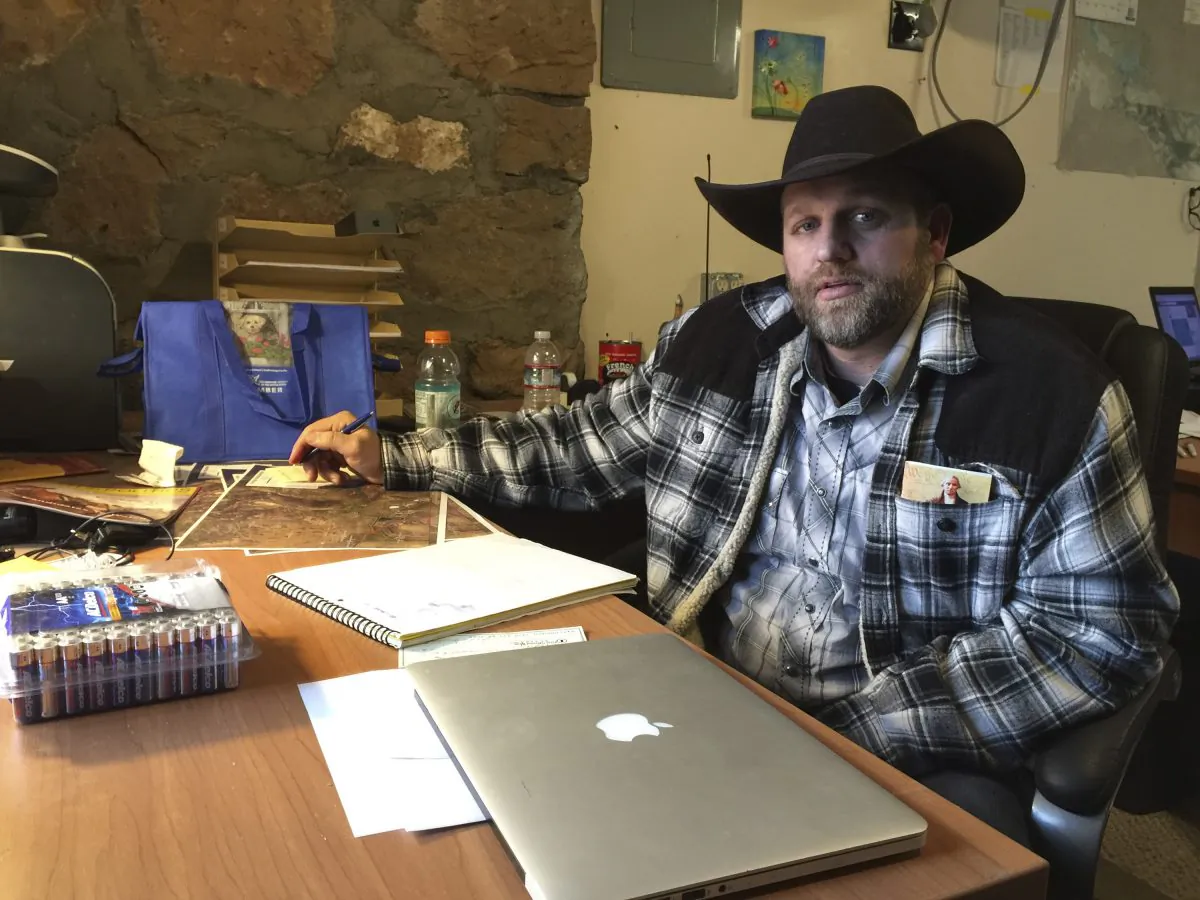Ammon Bundy sits at a desk he's using at the Malheur National Wildlife Refuge in Oregon on Jan. 22, 2016. Bundy is the leader of an armed group occupying a national wildlife refuge to protest federal land policies. The leader of an armed group occupying the refuge met briefly with a federal agent Friday, but left because the agent wouldn't talk with him in front of the media. (AP Photo/Keith Ridler)