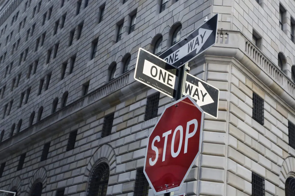 One way signs and a stop sign are posted in the financial district in front of the Federal Reserve Bank of New York on Jan. 15, 2016. (AP Photo/Mark Lennihan)