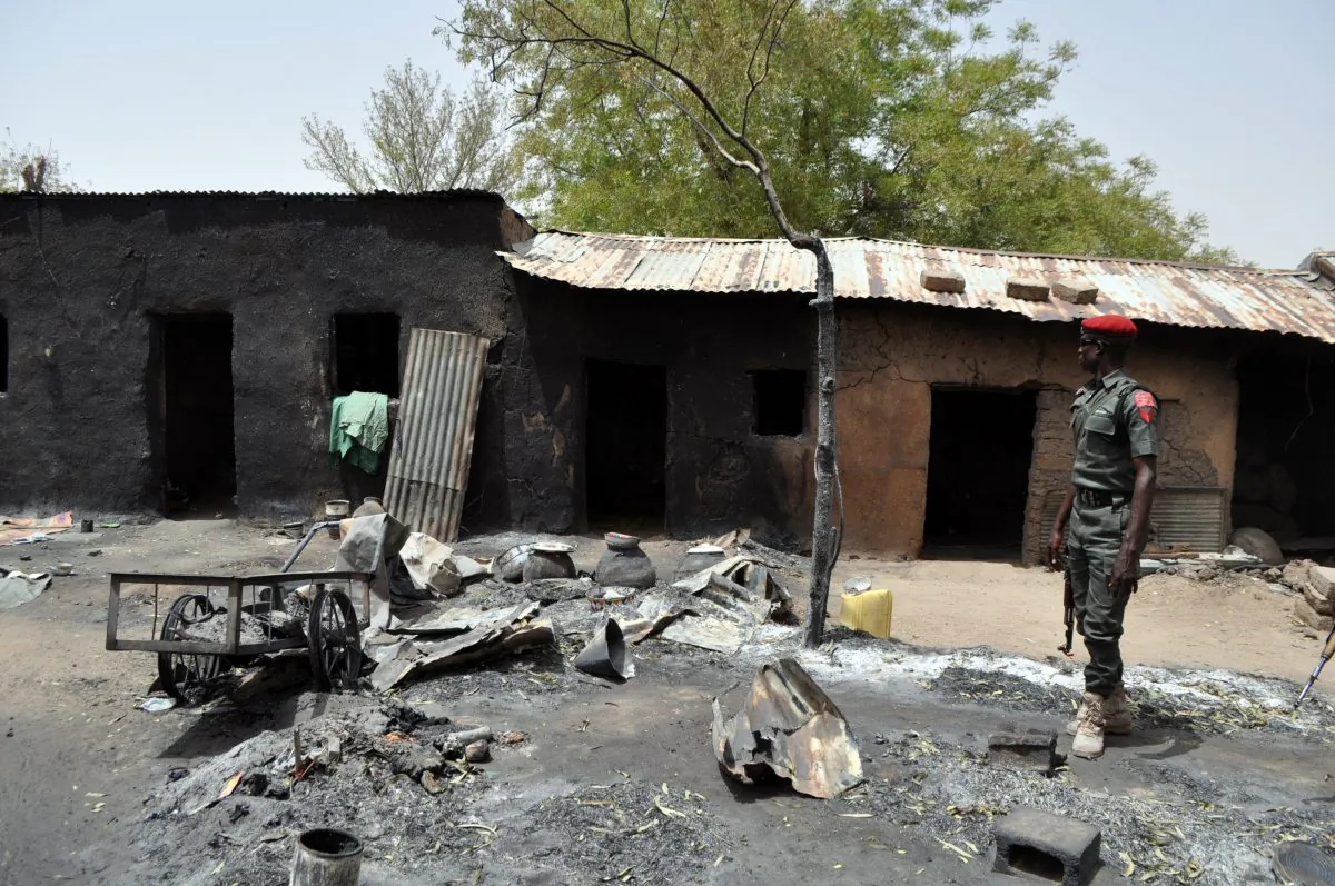 An anti-riot policeman stands in front of a burnt house in Gubio in Borno State, northeast Nigeria, on May 26, 2015. (Stringer/AFP/Getty Images)