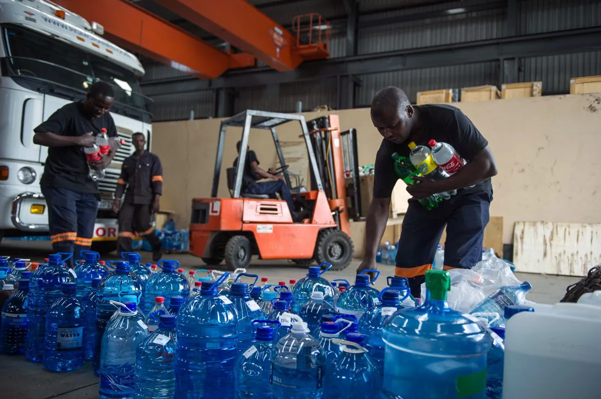 Factory workers pile up donated water bottles by South African residents from the Johannesburg outskirts town of Benoni to be delivered in drought stricken rural communities, on January 15, 2016 in Benoni, South Africa (MUJAHID SAFODIEN/AFP/Getty Images).