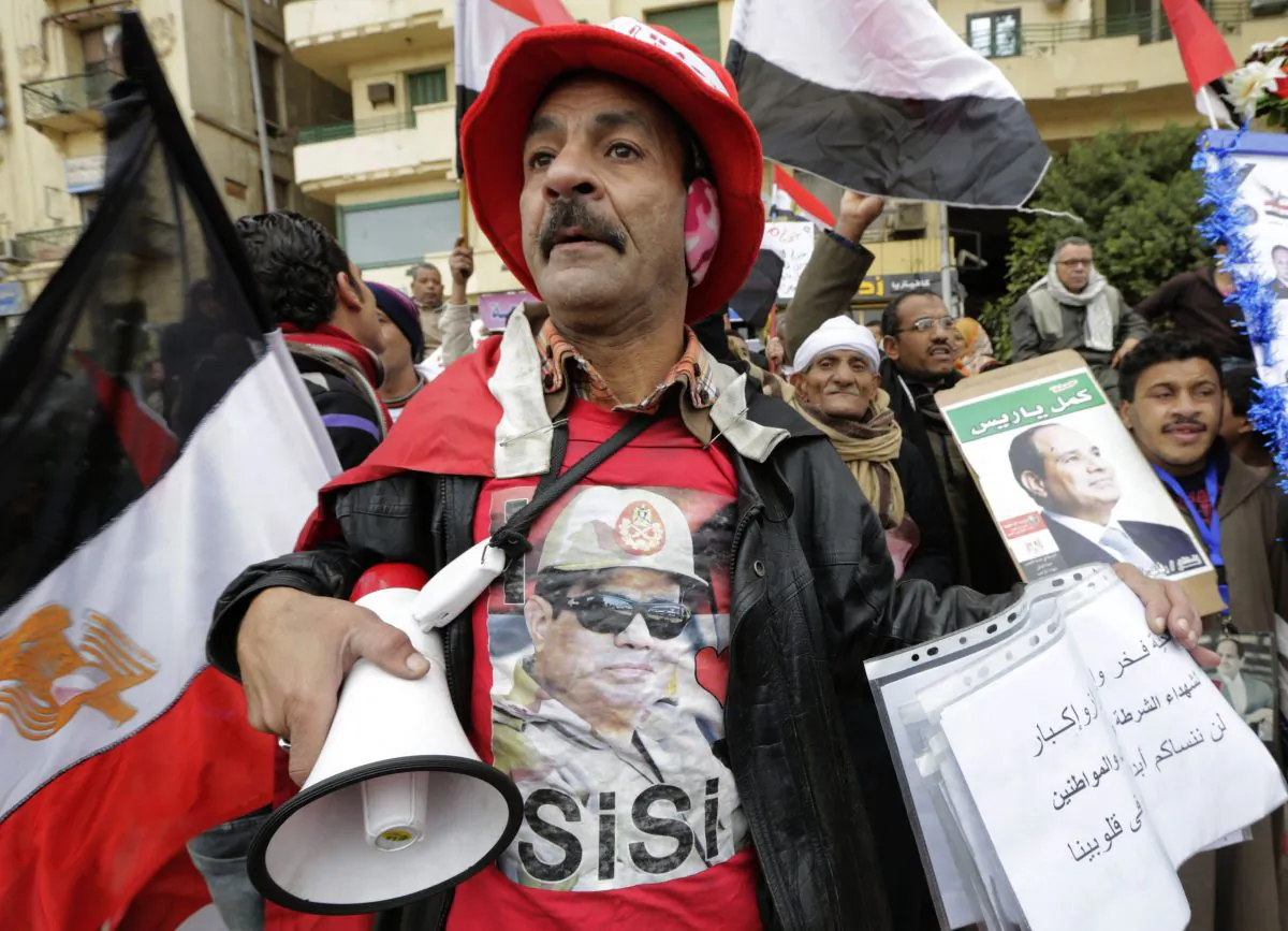 A small number of supporters of Egyptian President Abdel Fattah el-Sissi wave posters and national flags as they mark Police Day, which falls on Jan. 25, the anniversary of the 2011 uprising, in Tahrir Square, Cairo, Egypt, Monday, Jan. 25, 2016.  (AP Photo/Amr Nabil)