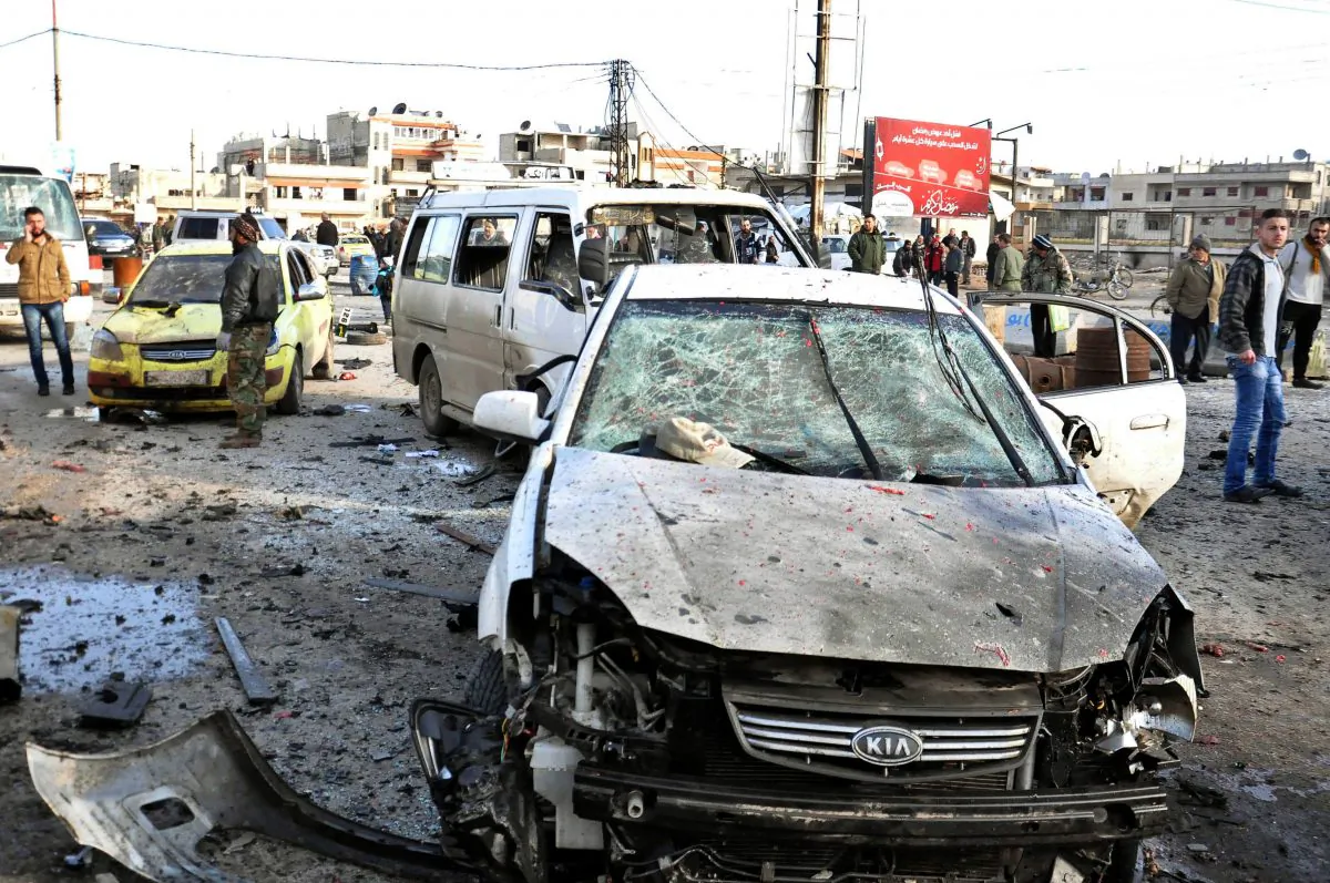 In this photo released by the Syrian official news agency SANA, Syrian citizens gather at the scene where twin bombs exploded at a government-run security checkpoint, at the neighborhood of Zahraa, in Homs province, Syria, Tuesday, Jan. 26, 2016. (SANA via AP)
