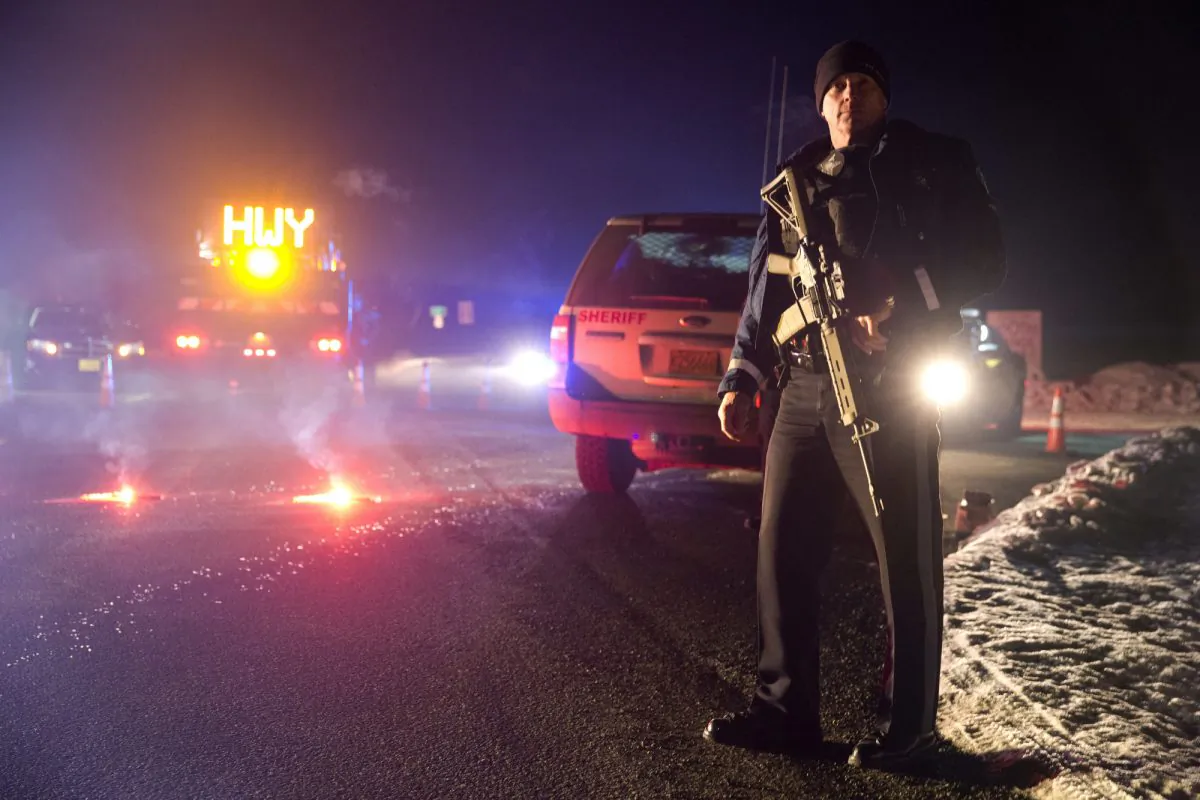 Sgt. Tom Hutchison stands in front of an Oregon State Police roadblock on Highway 395 on Tuesday, Jan. 26, 2016 between John Day and Burns, Ore.  The FBI on Tuesday arrested the leaders of an armed group that has occupied a federal wildlife refuge in eastern Oregon for the past three weeks.  (Dave Killen/The Oregonian via AP) 