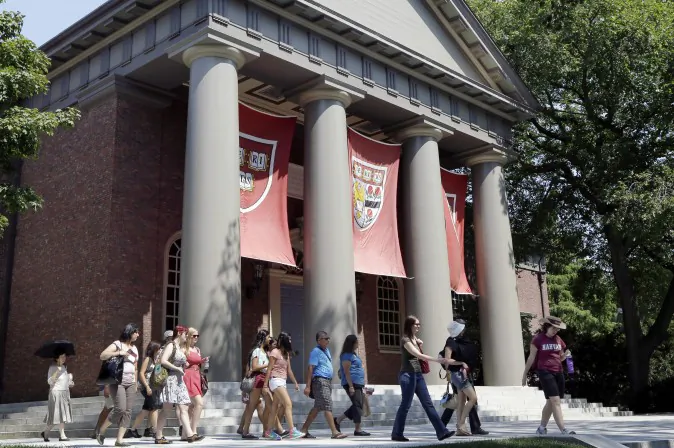 A tour group walks through the campus of Harvard University in Cambridge, Mass., Aug. 30, 2012. (AP Photo/Elise Amendola)