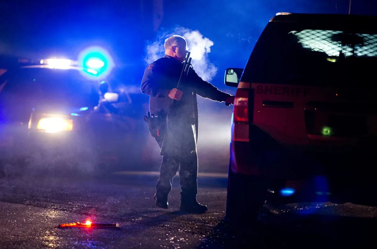 A Oregon State police officer stands by a vehicle as police officers block Highway 395 in Seneca, Ore., Tuesday, Jan. 26, 2016. (Dave Killen/The Oregonian via AP) 