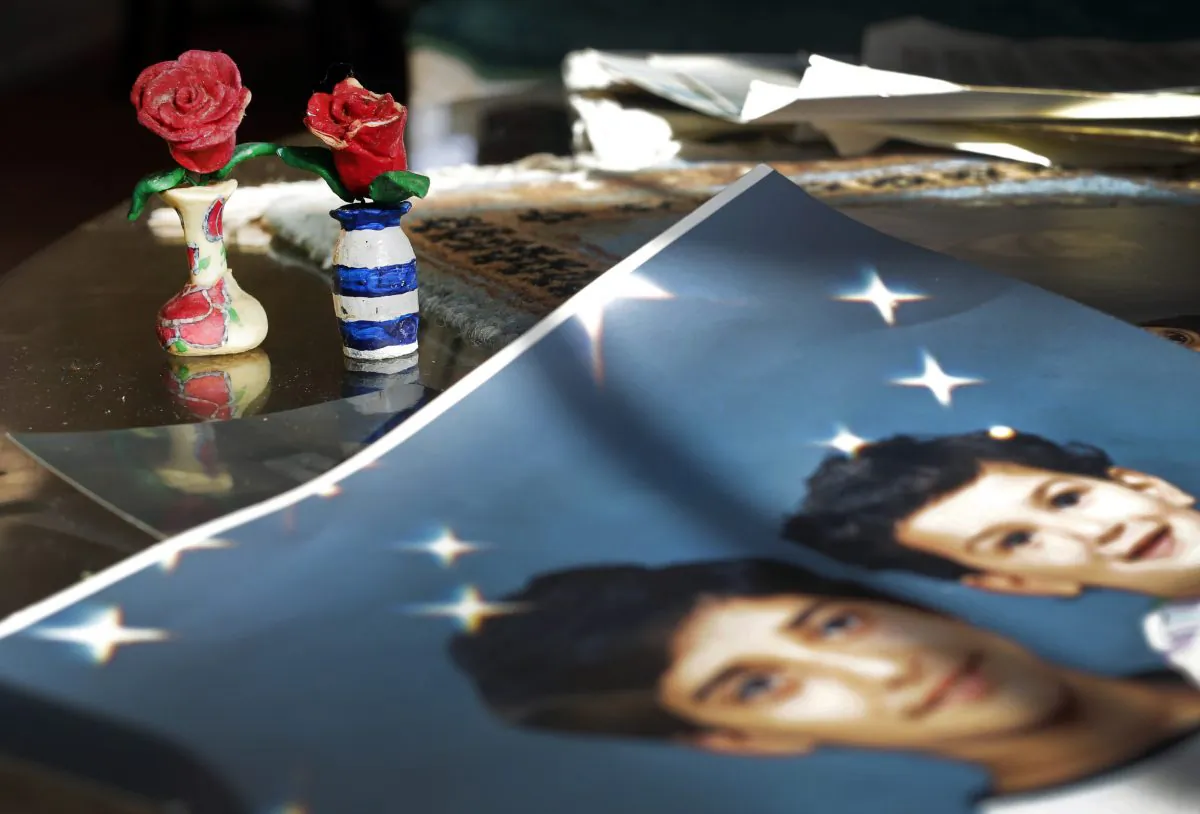 Prison artwork created by Adnan Syed sits near family photos in the home of his mother, Shamim Syed, Wednesday, Dec. 10, 2014, in Baltimore. (AP Photo/Patrick Semansky)