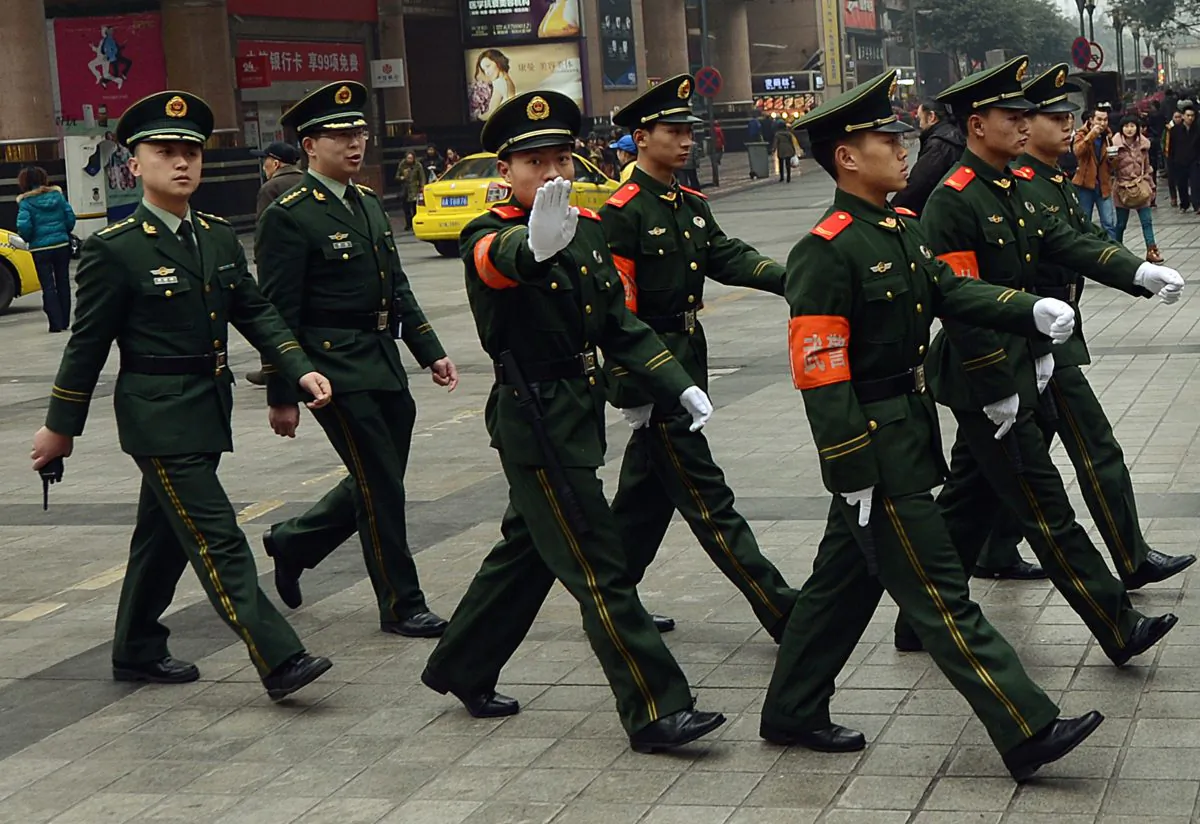 Chinese paramilitary police marching through the downtown shopping area of Chongqing in February 2013. Chinese authorities recently indicted a Canadian for allegedly stealing state secrets. (Mark Ralston/AFP/Getty Images)