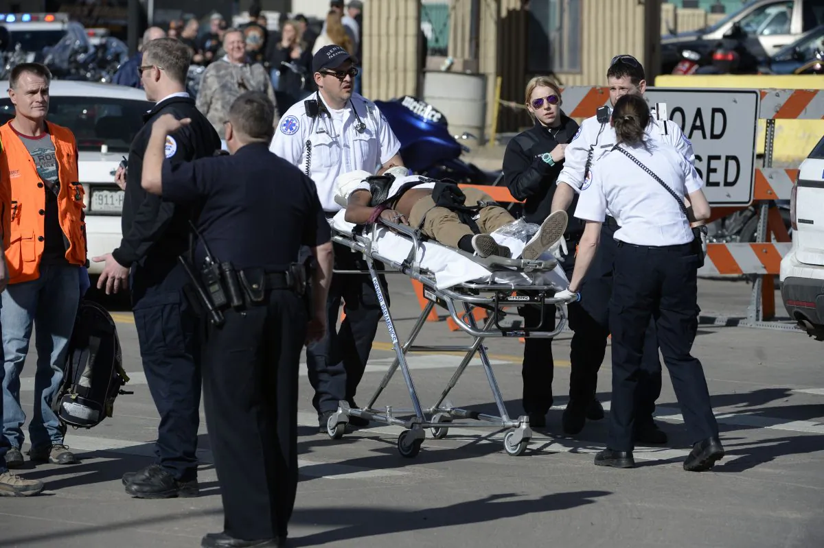 Paramedics transport a man to an awaiting ambulance at the National Western Complex in Denver on Jan. 30, 2016. Denver police say multiple people were injured in a deadly stabbing and shooting at The Colorado Motorcycle Expo. (Andy Cross/The Denver Post via AP)