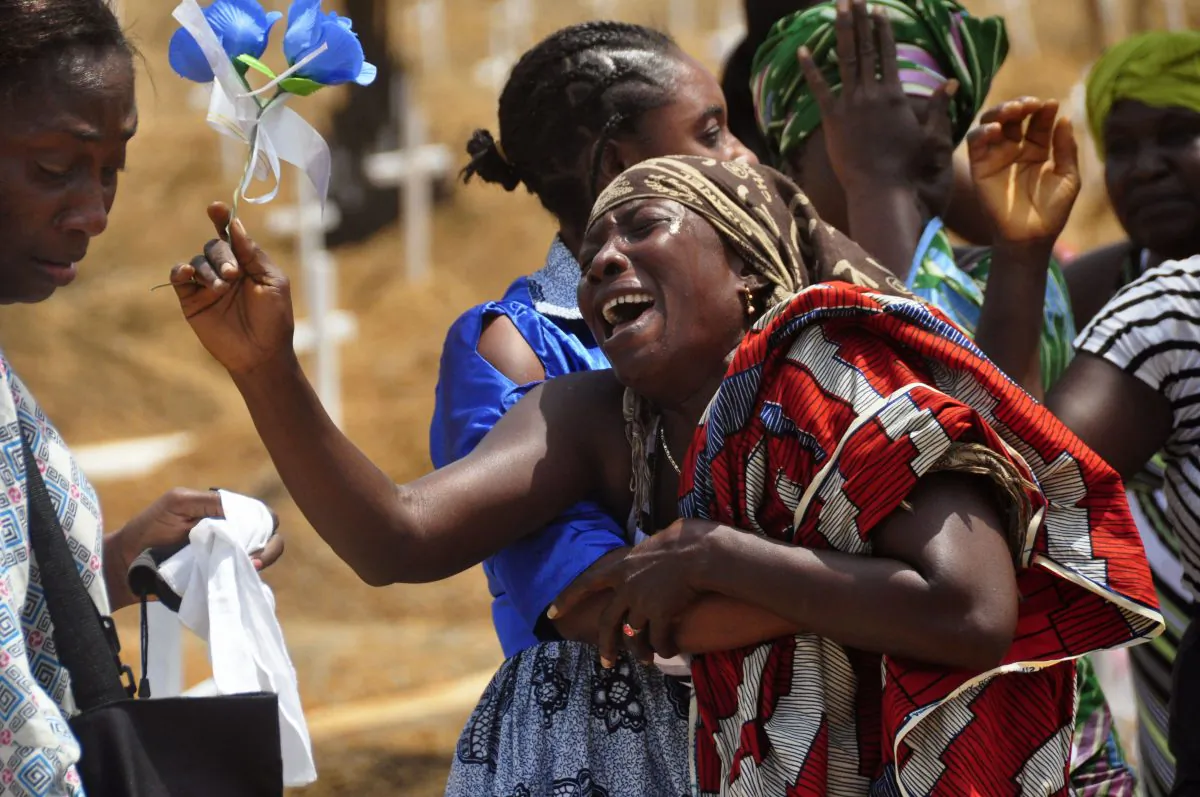 In this Wednesday March 11, 2015 file photo, relatives weep as they bury a loved one suspected of dying from the Ebola virus at a new graveyard on the outskirts of Monrovia, Liberia. Activists say international donors have failed to deliver promised funds to help West African countries recover from the Ebola epidemic that killed more than 11,000 people. Oxfam said Sunday, Jan. 31, 2016, that $1.9 billion has not been delivered. (AP Photo/Abbas Dulleh, File)