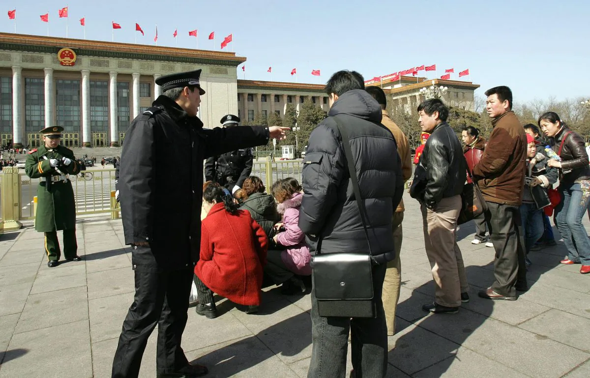 A policeman (L) shouts at suspected protesters to make them kneel down in Beijing on March 7, 2005. Chinese officials have interesting takes on some social issues. (Peter Parks/AFP/Getty Images)
