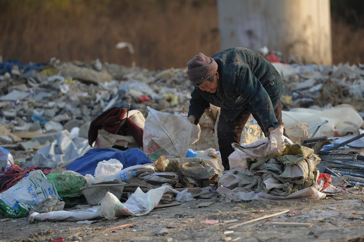 An elderly scavenger picks up construction waste from a garbage dump in Hefei, Anhui Province on Dec. 9, 2012. Police roughed up two senior scavengers for violating traffic in Henan Province. (STR/AFP/Getty Images)