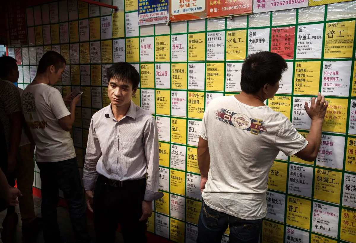 Men look at job postings on a bulletin board at a centre in Yiwu in Zhejiang Province, China on Sept. 18, 2015. (Kevin Frayer/Getty Images)