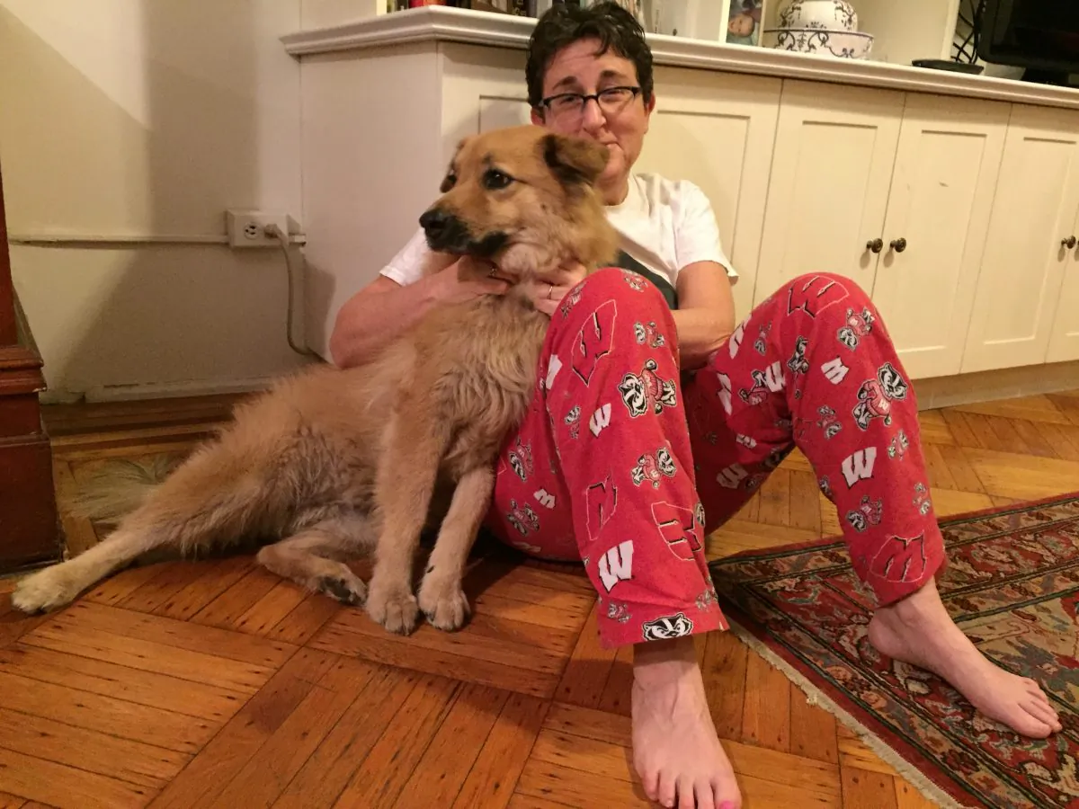 Penny, a mixed-breed rescue dog, poses with her owner, Margery Cooper, in Brooklyn on Tuesday, Feb. 2, 2016 in New York.  Cooper's previous dog died of complications from Lyme disease and she is vigilant about checking Penny for ticks. Experts say climate change has increased the prevalence of fleas, ticks and heartworm disease for pets in the U.S. (AP Photos/Beth J. Harpaz)
