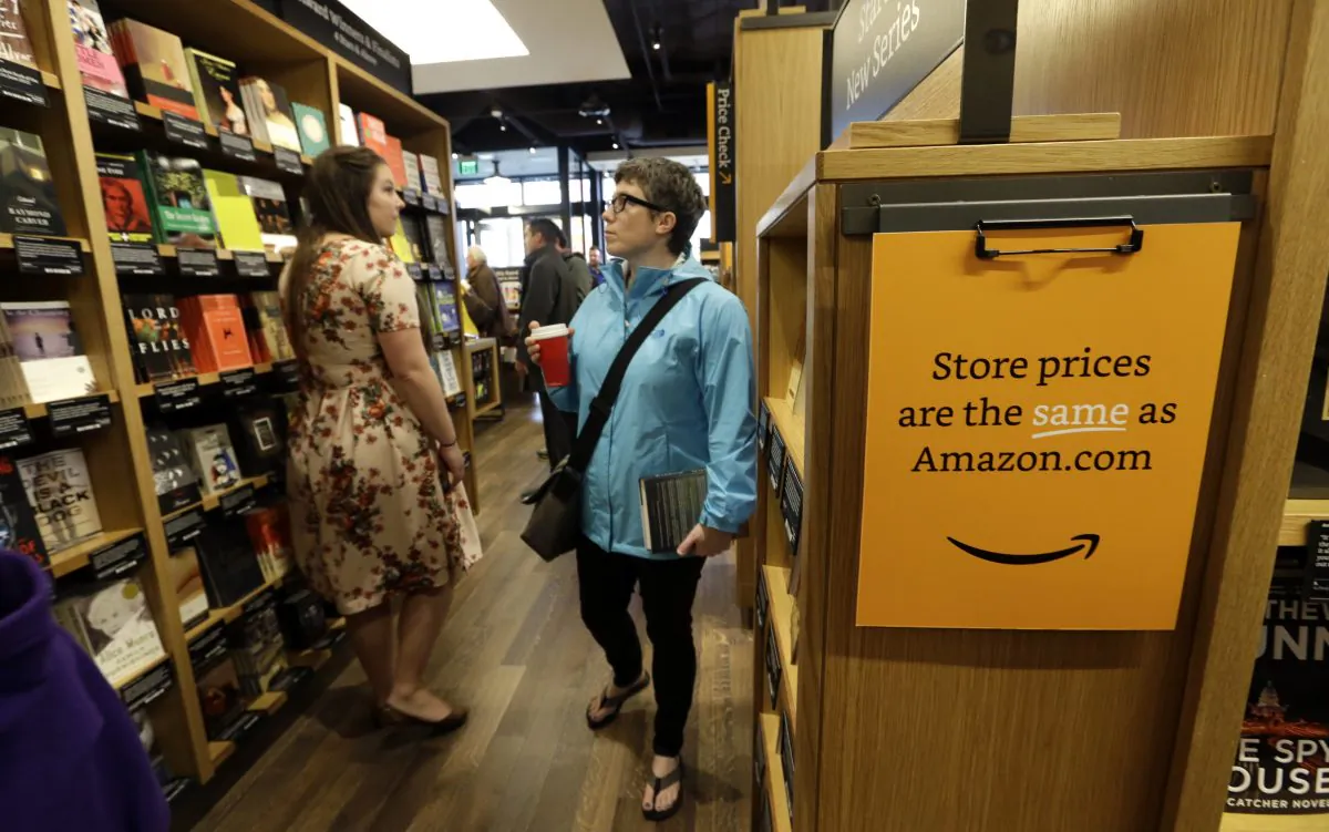 Customers browse aisles at the opening day for Amazon Books, the first brick-and-mortar retail store for online retail giant Amazon, Tuesday, Nov. 3, 2015, in Seattle. (AP Photo/Elaine Thompson)