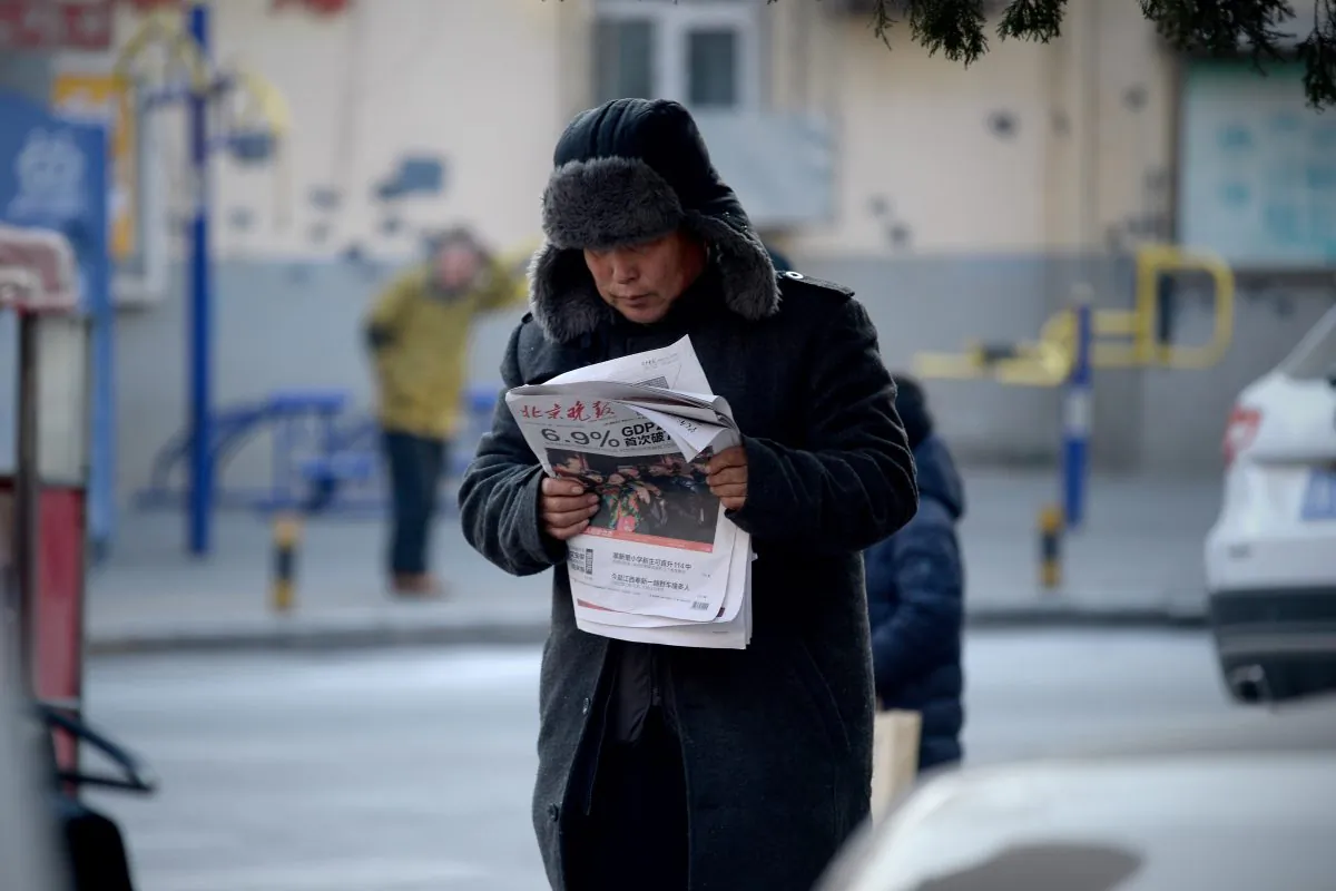 A man reads a newspaper with a front page headline that reads "China's GDP grows at 6.9 percent" in Beijing on Jan. 19, 2016. China's economy grew at its slowest pace in a quarter of a century last year as it undergoes a difficult transition. (WANG ZHAO/AFP/Getty Images)