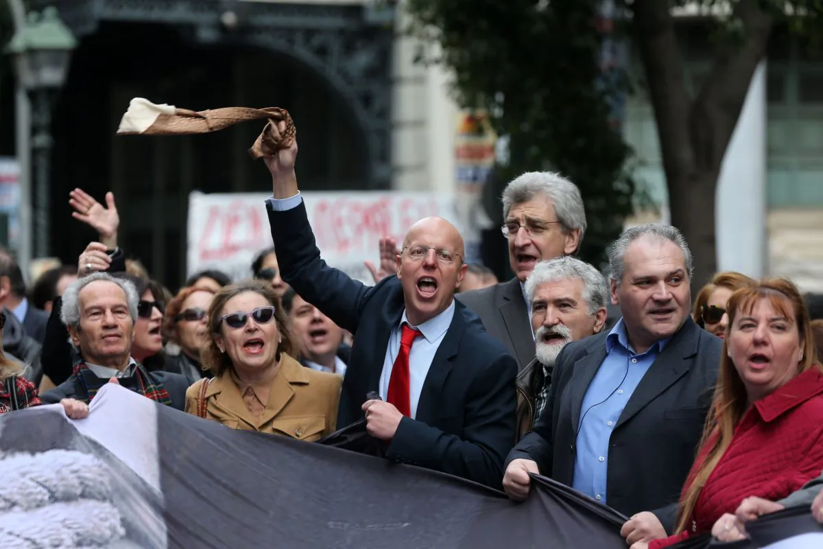 Protesting lawyers shout slogans as their colleague holds up during a 24-hour nationwide general strike in Athens, Thursday, Feb. 4, 2016.  (AP Photo/Petros Giannakouris)