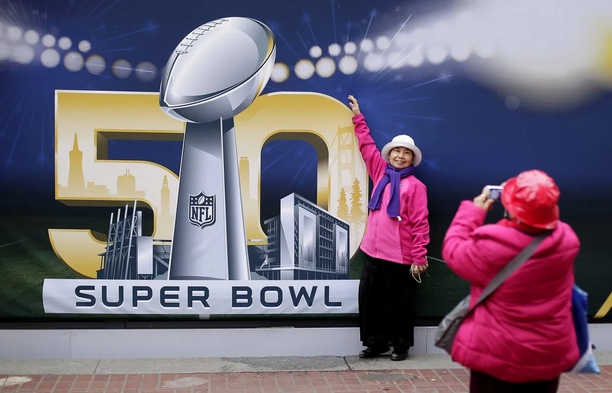 Angie Bagares poses for a photo in front of a Super Bowl 50 sign at Super Bowl City Wednesday, Feb. 3, 2016, in San Francisco. (AP Photo/Charlie Riedel)