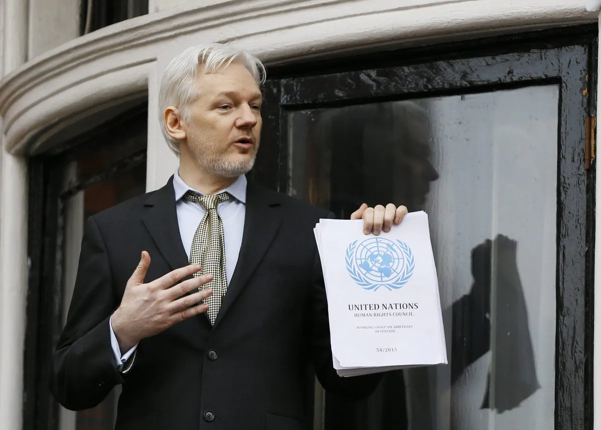 Wikileaks founder Julian Assange. holding a U.N. report speaks on the balcony of the Ecuadorean Embassy in London on Feb. 5, 2016. (AP Photo/Kirsty Wigglesworth)