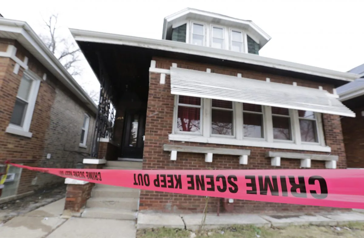 Crime scene tape surrounds a home Friday, Feb. 5, 2016, in Chicago. Chicago police are investigating what led to the deaths of two children, two women and two men whose bodies were found Thursday, with signs of trauma inside the home on the city's South Side. (AP Photo/M. Spencer Green)
